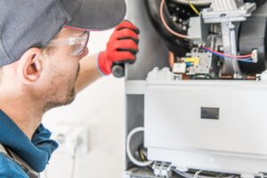 A professional technician repairing a furnace system